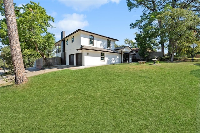 rear view of property featuring a garage and a yard