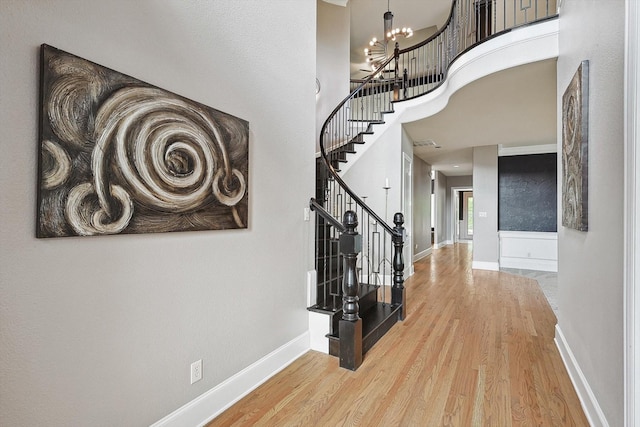 interior space featuring a high ceiling, a chandelier, and hardwood / wood-style floors