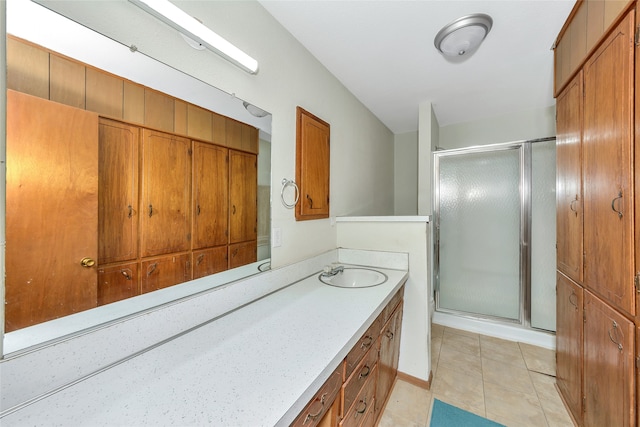 bathroom with walk in shower, vanity, and tile patterned flooring