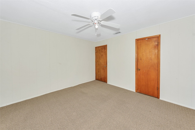 spare room featuring ceiling fan and carpet