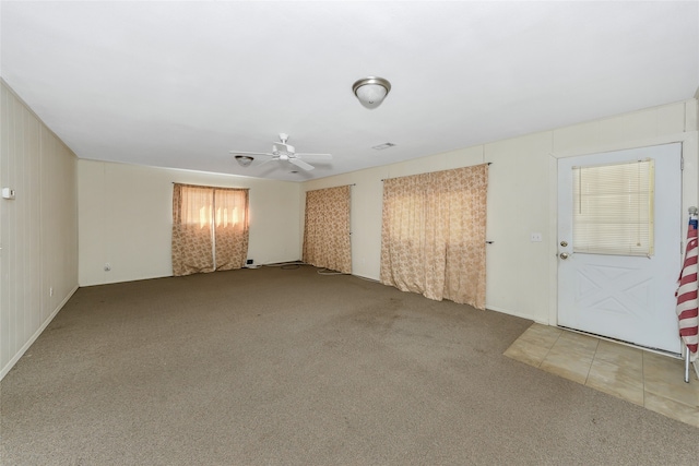 unfurnished room with ceiling fan and carpet