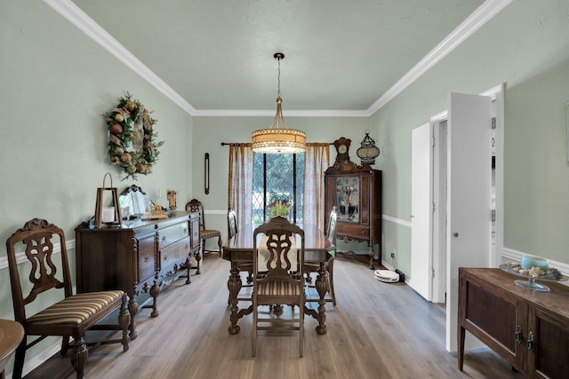 dining area featuring light hardwood / wood-style flooring and crown molding