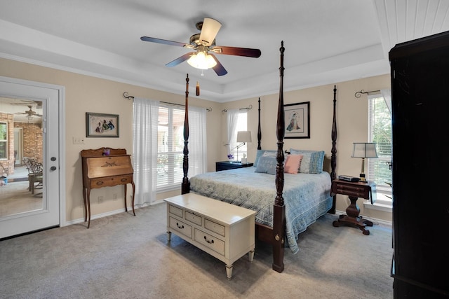 carpeted bedroom featuring a tray ceiling and ceiling fan