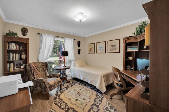 bedroom with crown molding, hardwood / wood-style floors, and a textured ceiling