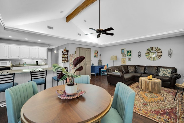 dining room featuring ceiling fan, vaulted ceiling with beams, and dark hardwood / wood-style floors