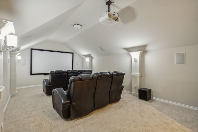 carpeted home theater room with vaulted ceiling