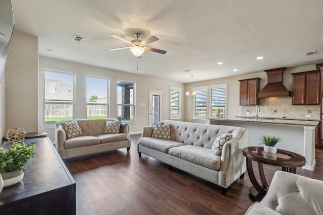 living room featuring ceiling fan and dark hardwood / wood-style flooring