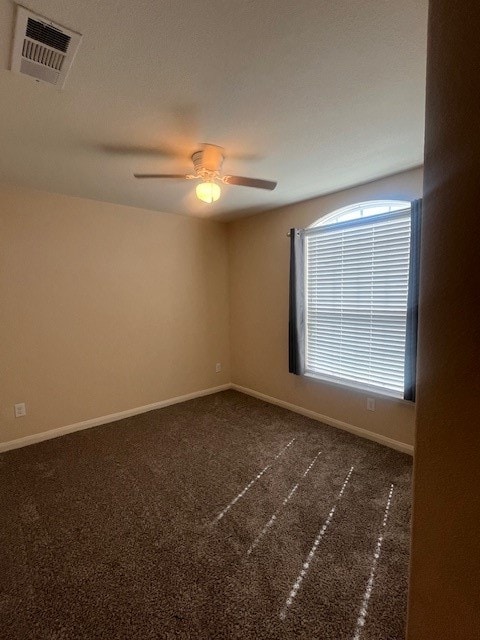 carpeted spare room featuring ceiling fan