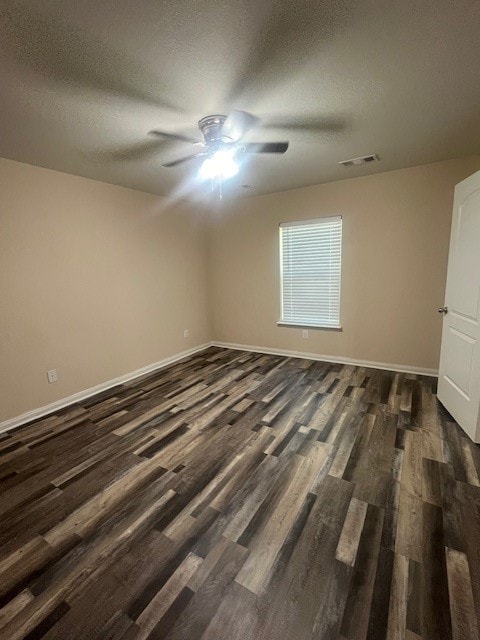 empty room with a textured ceiling, dark hardwood / wood-style floors, and ceiling fan