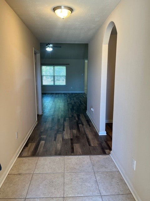 hallway with wood-type flooring and a textured ceiling