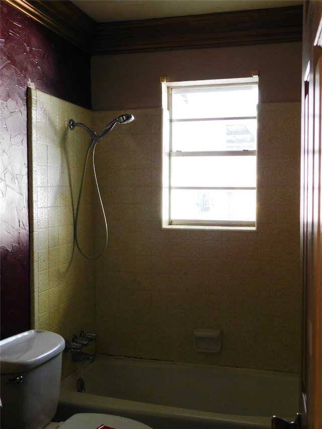 bathroom with tiled shower / bath combo and toilet