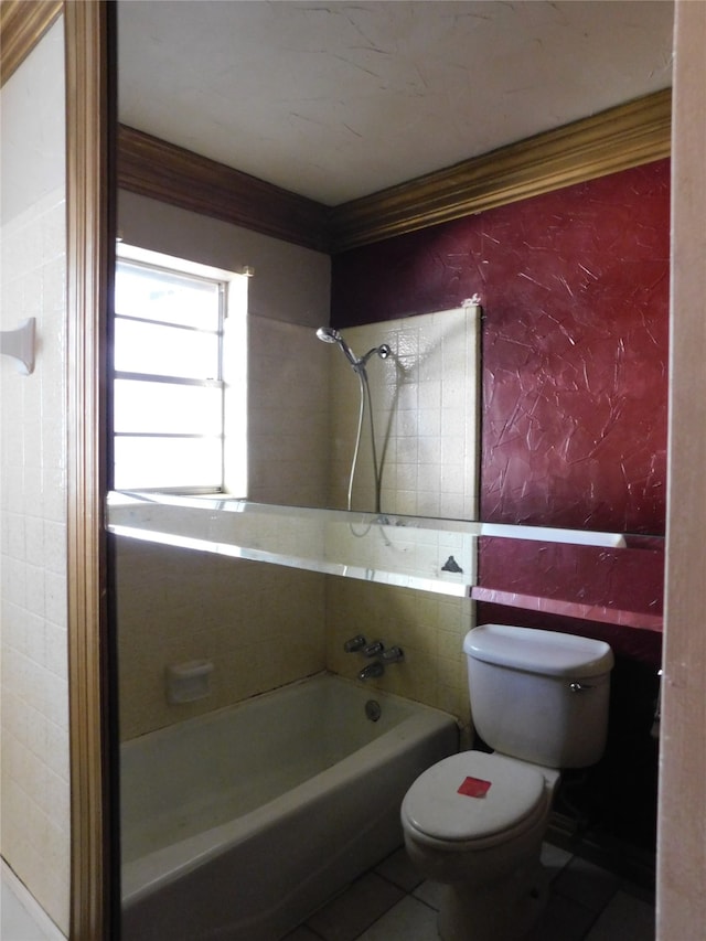 bathroom with tile patterned floors, tiled shower / bath, and toilet