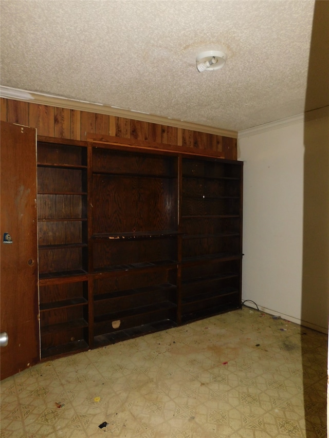 basement with a textured ceiling and crown molding