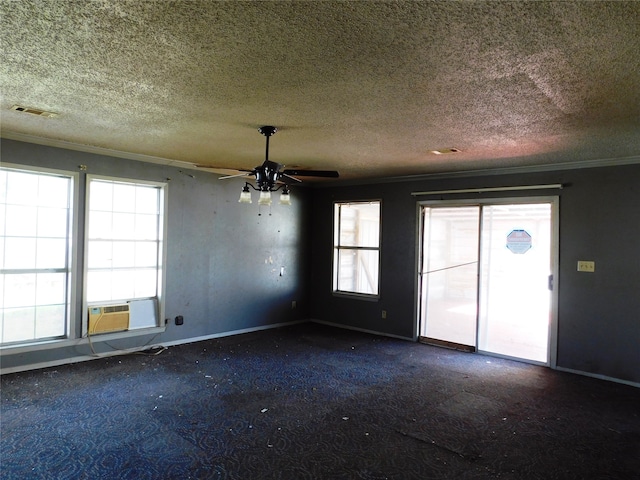 carpeted spare room with plenty of natural light, cooling unit, a textured ceiling, and ornamental molding