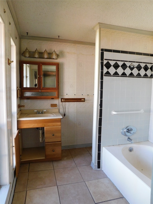 bathroom featuring tile walls, tile patterned flooring, a textured ceiling, and sink