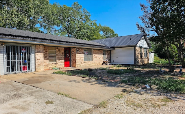 420 Lawson Ln, Pilot Point, TX 76258 - ranch-style house with brick siding, solar panels, and a metal roof