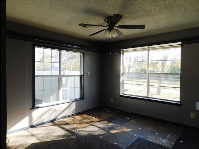 empty room featuring ceiling fan and a textured ceiling