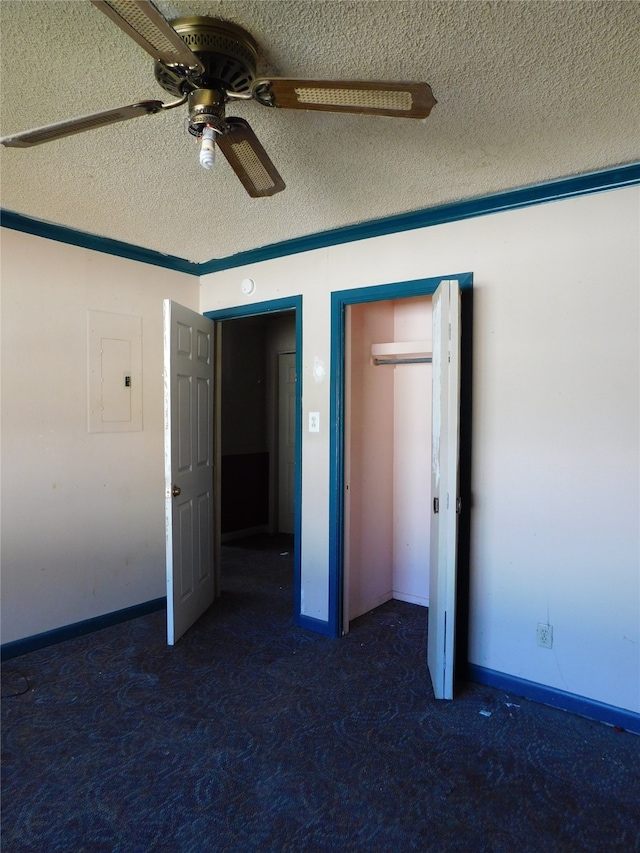 unfurnished bedroom with dark colored carpet, ceiling fan, a textured ceiling, and electric panel