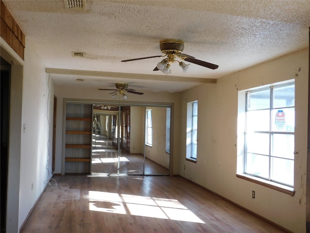 spare room featuring hardwood / wood-style flooring, ceiling fan, and a textured ceiling