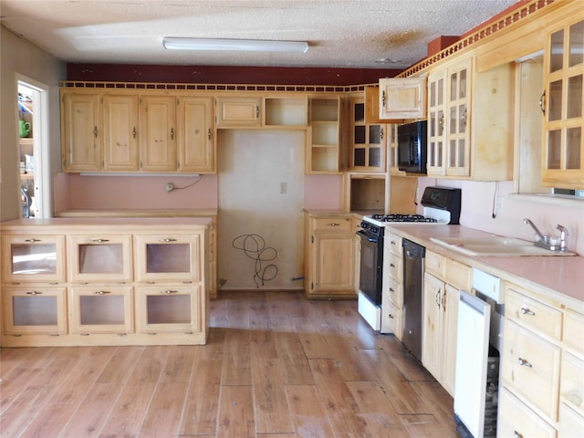 kitchen with a textured ceiling, white appliances, light hardwood / wood-style floors, and sink