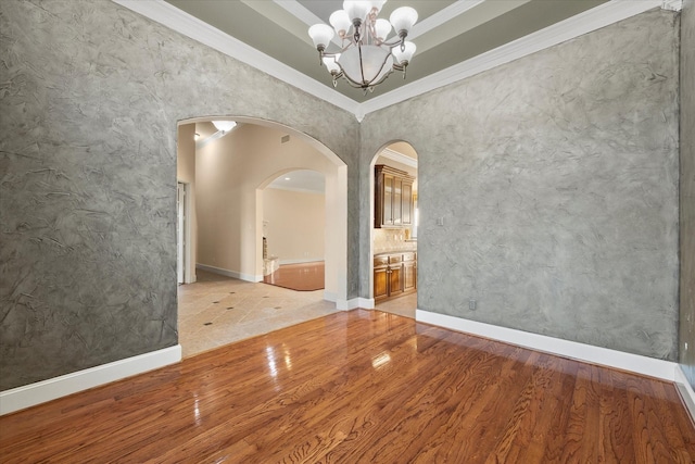 unfurnished dining area with ornamental molding, a chandelier, and hardwood / wood-style floors