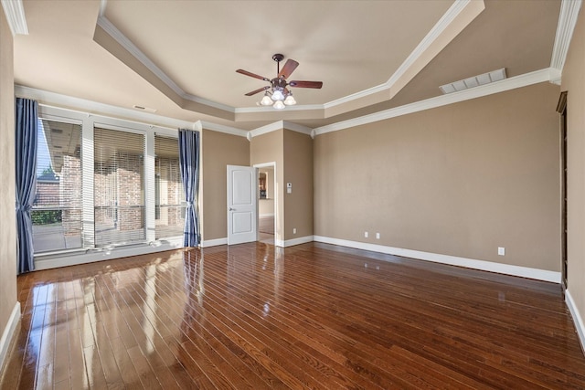 empty room with ceiling fan, ornamental molding, dark hardwood / wood-style flooring, and a raised ceiling