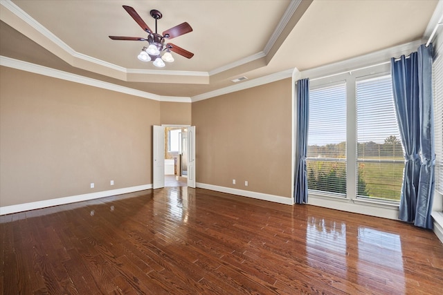 spare room with hardwood / wood-style flooring, crown molding, ceiling fan, and a tray ceiling