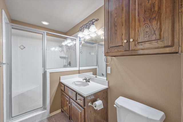 bathroom featuring toilet, vanity, tile patterned floors, and walk in shower