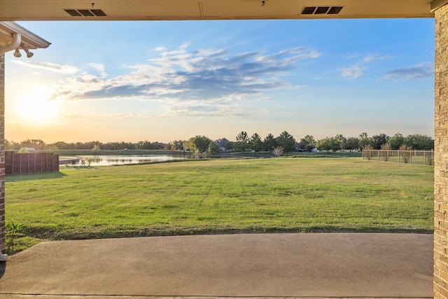 yard at dusk with a rural view and a water view