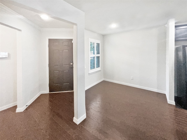 entryway with dark carpet and ornamental molding