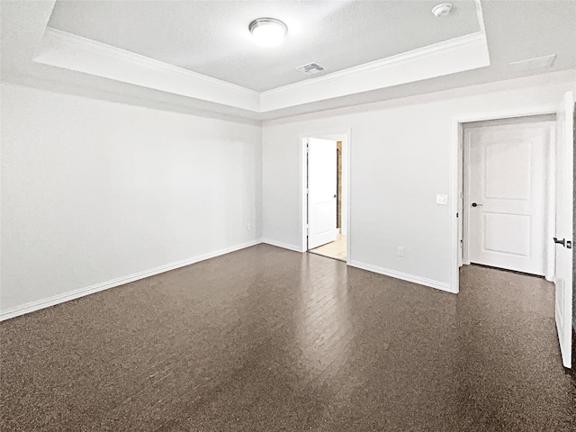 spare room with a textured ceiling, crown molding, and a raised ceiling