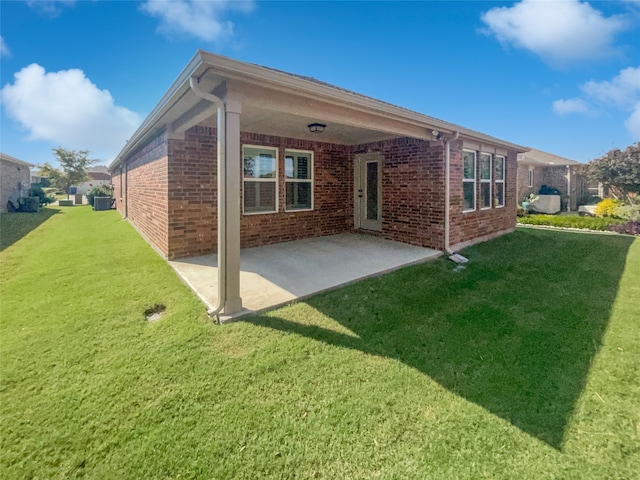 back of house with a patio and a lawn