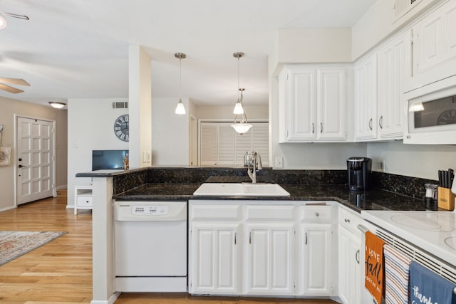 kitchen with light hardwood / wood-style flooring, dark stone counters, white appliances, and white cabinetry