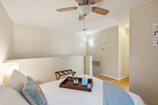 bedroom with ceiling fan, connected bathroom, and light hardwood / wood-style floors