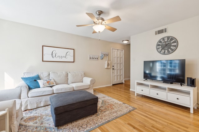 living room featuring wood-type flooring and ceiling fan