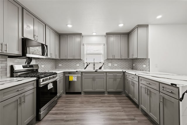 kitchen featuring stainless steel appliances, dark hardwood / wood-style floors, sink, and gray cabinetry