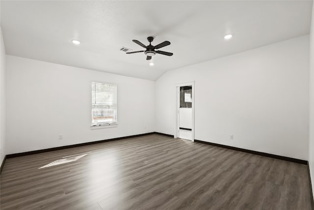 spare room with ceiling fan, vaulted ceiling, and dark wood-type flooring