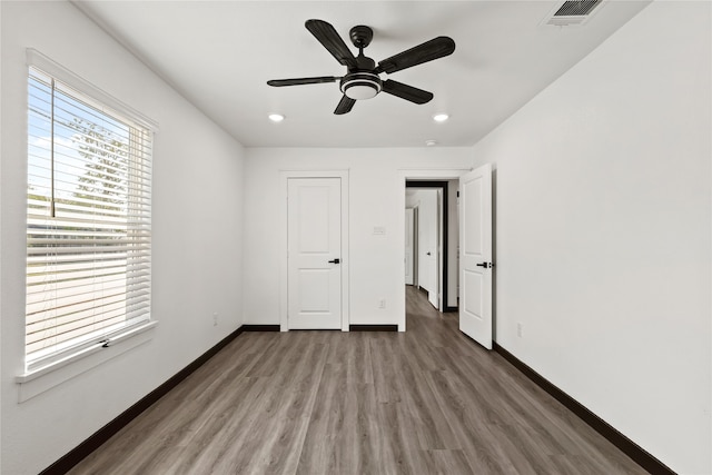 unfurnished bedroom with ceiling fan and dark hardwood / wood-style flooring