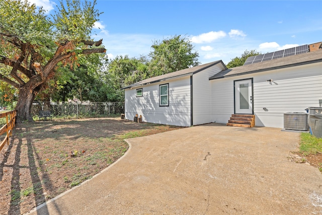 rear view of property with central AC unit and a patio