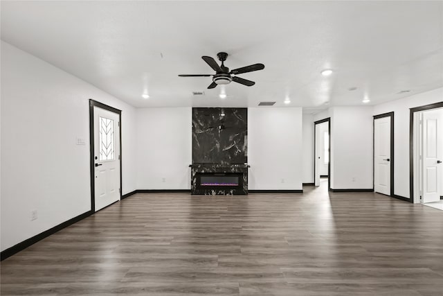 unfurnished living room with dark hardwood / wood-style flooring and ceiling fan