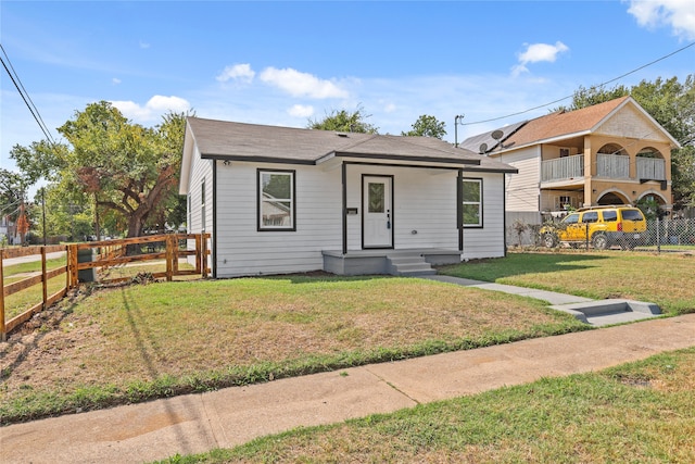 bungalow-style home featuring a balcony and a front lawn