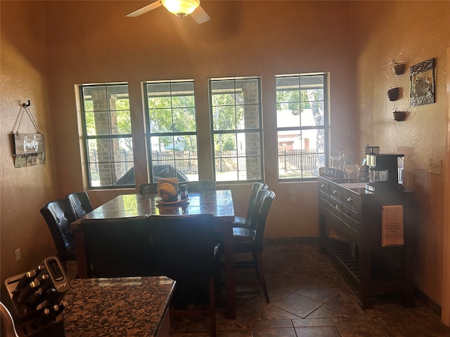 tiled dining space with ceiling fan