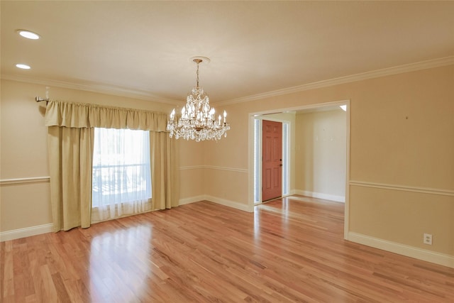 unfurnished room featuring a chandelier, hardwood / wood-style floors, and ornamental molding