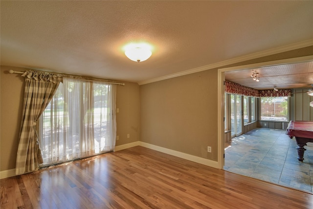 unfurnished room with crown molding, wood-type flooring, a textured ceiling, and billiards