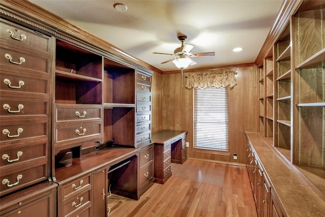 office featuring ceiling fan, light hardwood / wood-style flooring, a textured ceiling, built in desk, and ornamental molding