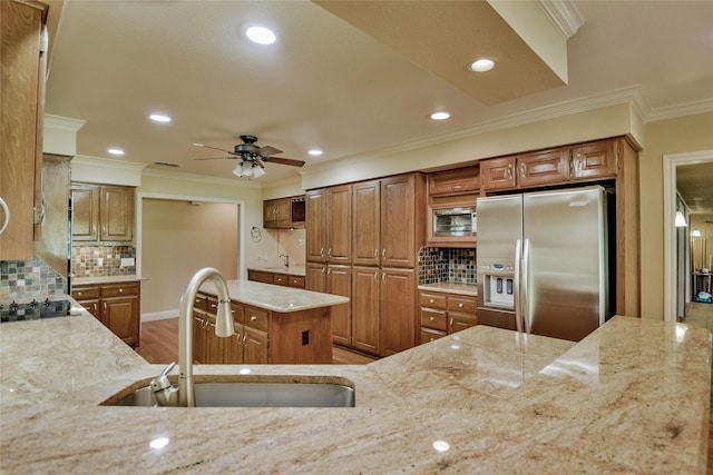 kitchen with sink, stainless steel fridge with ice dispenser, light stone counters, backsplash, and hardwood / wood-style flooring