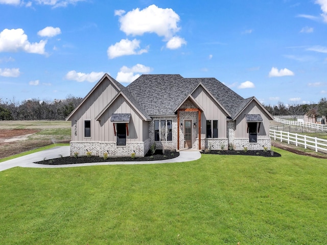 modern inspired farmhouse featuring a front lawn, fence, and board and batten siding