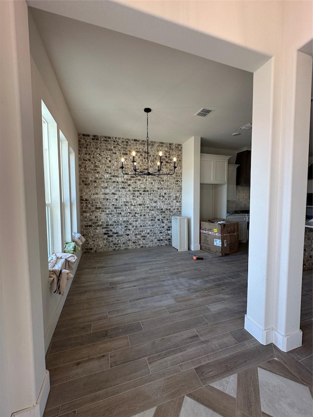 unfurnished dining area featuring dark hardwood / wood-style floors and a chandelier