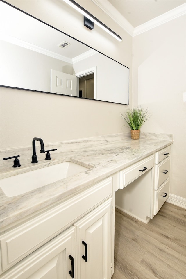 bathroom featuring hardwood / wood-style flooring, crown molding, and vanity