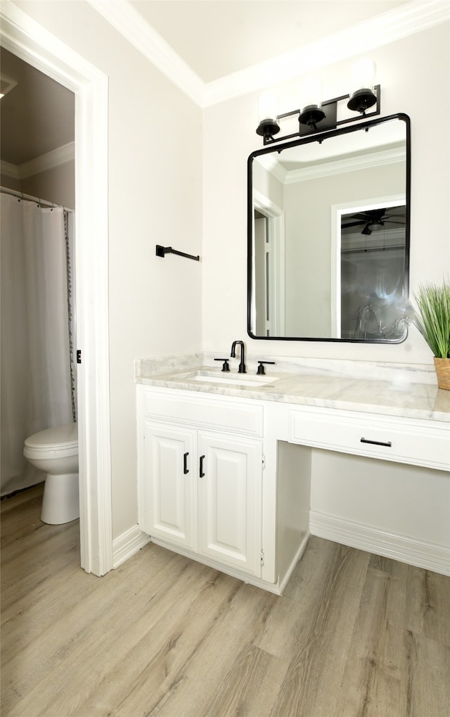 bathroom featuring crown molding, hardwood / wood-style floors, vanity, and toilet